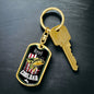 a gold keychain with a black background and a red, white, and
