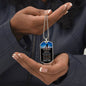a woman holding a dog tag with a picture on it