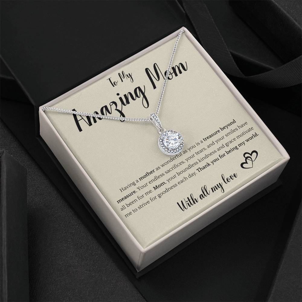 The image shows a card with a silver necklace featuring interlocking rings. The card reads "To My Amazing Mom" at the top, with a heartfelt message below about the mother's sacrifices and kindness. It ends with "With all my love" and a heart illustration.