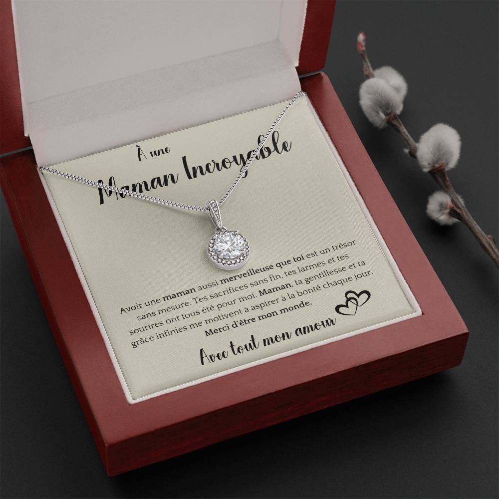 The image shows a card with a silver necklace featuring a round pendant with a central gemstone. The card reads "À une Maman Incroyable" at the top, with a heartfelt French message about the mother's sacrifices and kindness. It ends with "Avec tout mon amour" and a heart illustration.