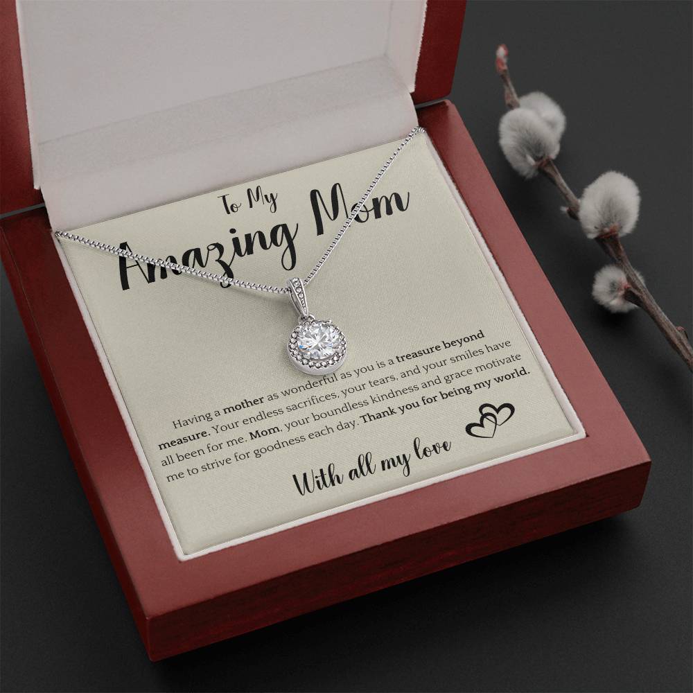 The image shows a card with a silver necklace featuring interlocking rings. The card reads "To My Amazing Mom" at the top, with a heartfelt message below about the mother's sacrifices and kindness. It ends with "With all my love" and a heart illustration.