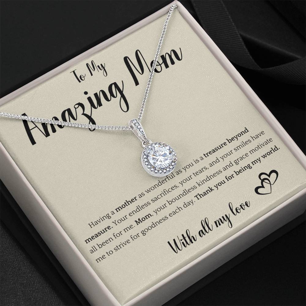 The image shows a card with a silver necklace featuring interlocking rings. The card reads "To My Amazing Mom" at the top, with a heartfelt message below about the mother's sacrifices and kindness. It ends with "With all my love" and a heart illustration.