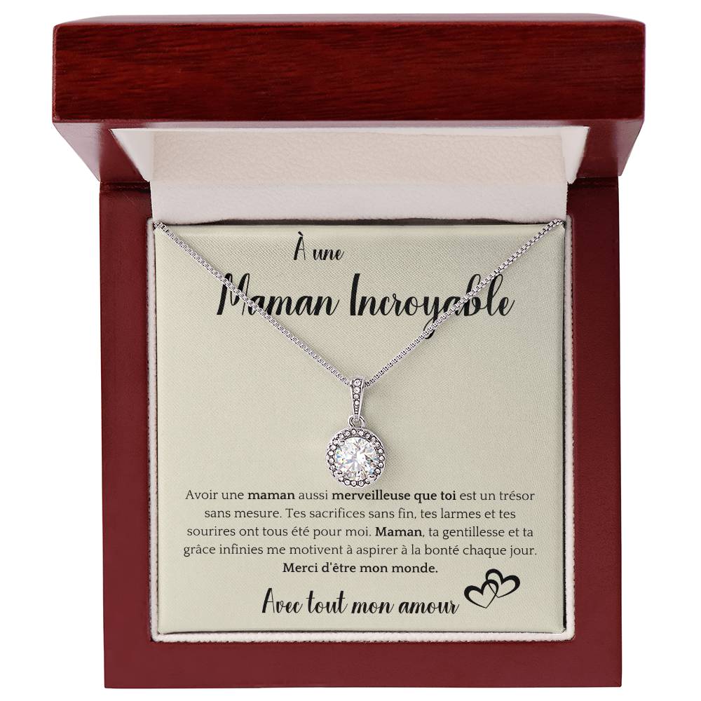 The image shows a card with a silver necklace featuring a round pendant with a central gemstone. The card reads "À une Maman Incroyable" at the top, with a heartfelt French message about the mother's sacrifices and kindness. It ends with "Avec tout mon amour" and a heart illustration.