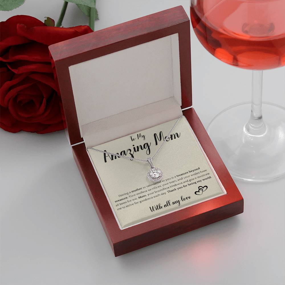 The image shows a card with a silver necklace featuring interlocking rings. The card reads "To My Amazing Mom" at the top, with a heartfelt message below about the mother's sacrifices and kindness. It ends with "With all my love" and a heart illustration.