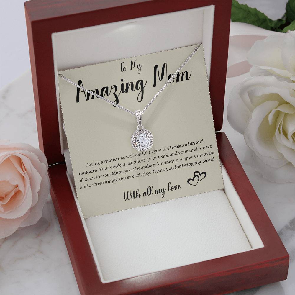 The image shows a card with a silver necklace featuring interlocking rings. The card reads "To My Amazing Mom" at the top, with a heartfelt message below about the mother's sacrifices and kindness. It ends with "With all my love" and a heart illustration.