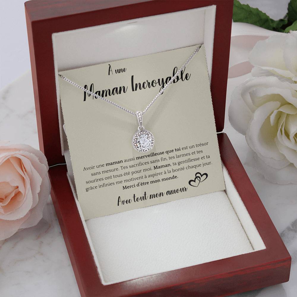 The image shows a card with a silver necklace featuring a round pendant with a central gemstone. The card reads "À une Maman Incroyable" at the top, with a heartfelt French message about the mother's sacrifices and kindness. It ends with "Avec tout mon amour" and a heart illustration.