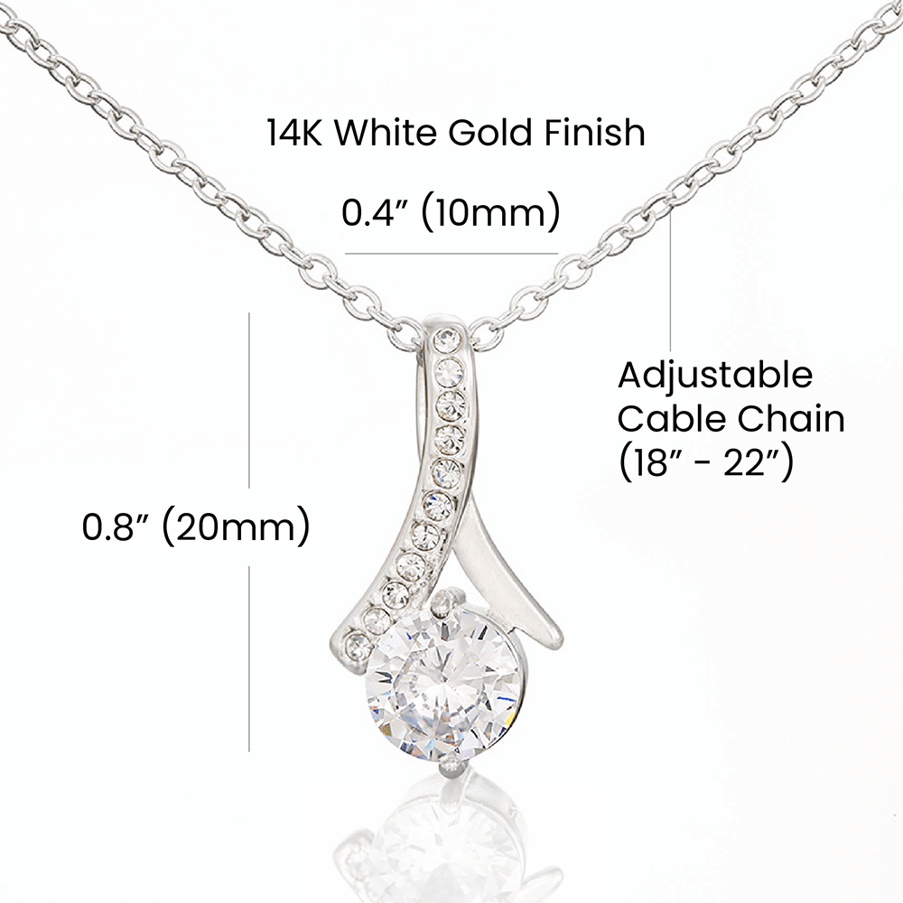 A necklace with a gemstone pendant in an open jewelry box with a loving message printed inside for girlfriend