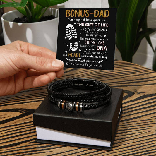 Hand holding a heartfelt card for a bonus dad next to a stylish black bracelet, perfect for showing appreciation and love