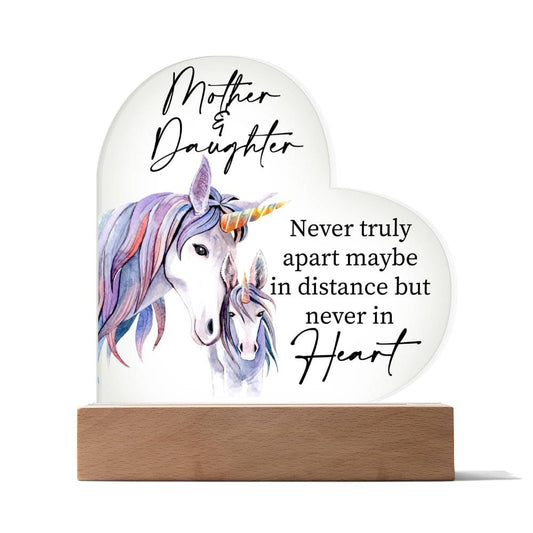 a glass heart with a picture of a unicorn and a quote on it