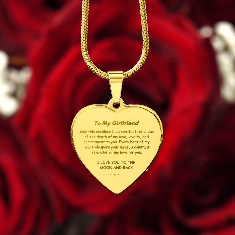 Heart-shaped silver pendant necklace with an engraved message hanging from a snake chain.