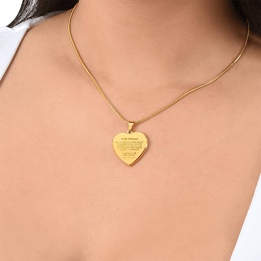 Heart-shaped silver pendant necklace with an engraved message hanging from a snake chain.