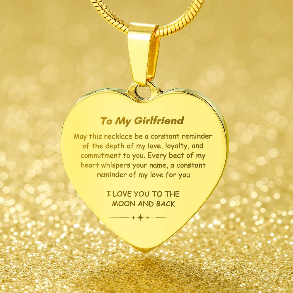 Heart-shaped silver pendant necklace with an engraved message hanging from a snake chain.