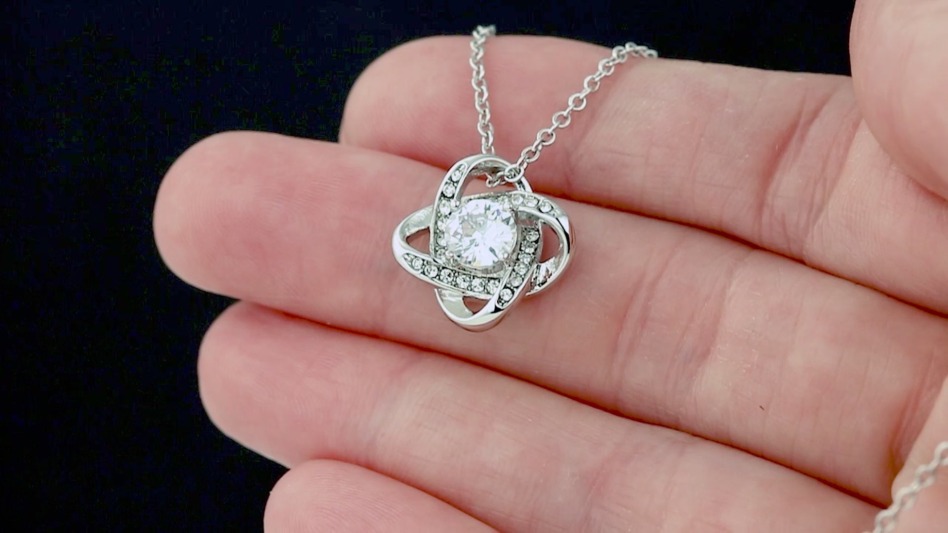 Necklace with an intertwined, sparkling pendant in a gift box for daughter.