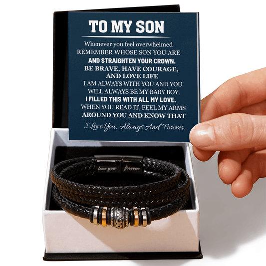 Black leather bracelet with engraved message in a box held by a hand
